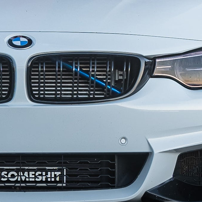 BMW F3x with F8x mirrors and m performance lip skirt that is a car parked in a parking lot with a red building in the background. Las vegas los angeles car